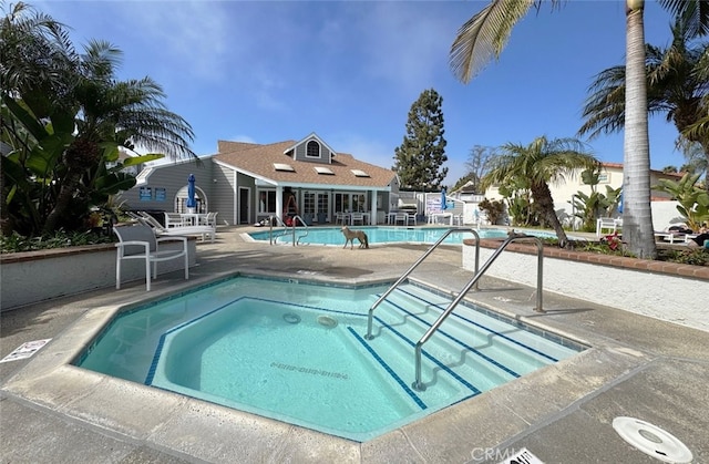 community pool featuring a community hot tub and a patio area