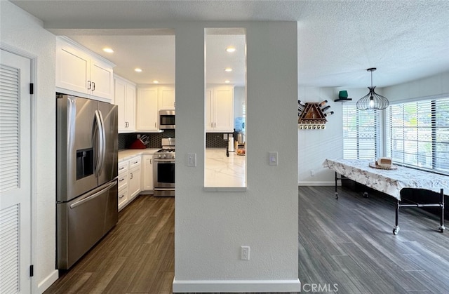 kitchen featuring stainless steel appliances, dark wood finished floors, and white cabinetry