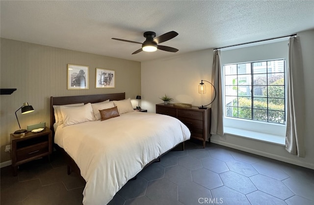 bedroom with a ceiling fan and a textured ceiling