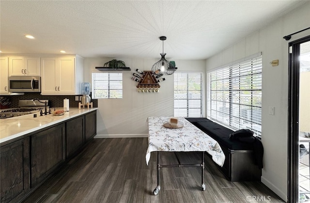 dining room featuring dark wood-style floors, baseboards, a textured ceiling, and recessed lighting