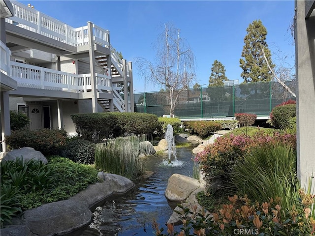 view of property's community featuring fence and stairs