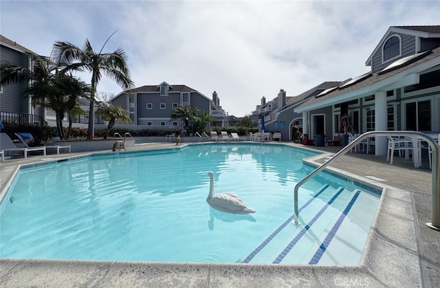 pool featuring a patio and a residential view