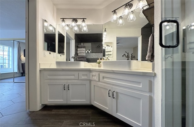 bathroom with a stall shower, a sink, and double vanity