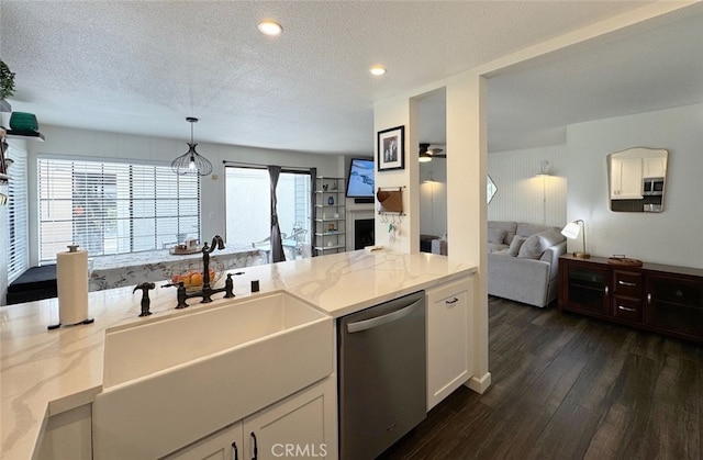 kitchen with open floor plan, dark wood-style flooring, light stone countertops, stainless steel appliances, and a sink