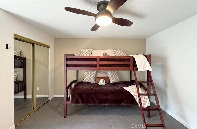 bedroom with a ceiling fan, baseboards, and a closet