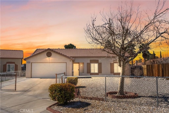 mediterranean / spanish home featuring a garage, fence, concrete driveway, a tiled roof, and stucco siding