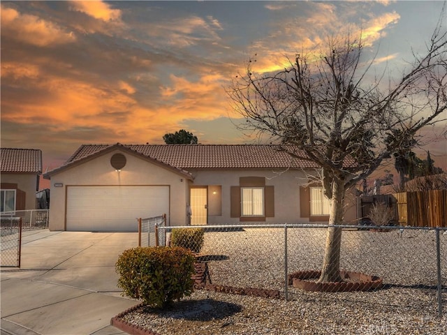 mediterranean / spanish-style home with a garage, concrete driveway, fence, and stucco siding