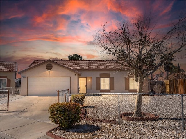 mediterranean / spanish home featuring a tile roof, stucco siding, an attached garage, fence, and driveway