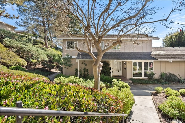 traditional home with a shingled roof and board and batten siding