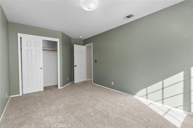 unfurnished bedroom featuring carpet floors, baseboards, visible vents, and a closet