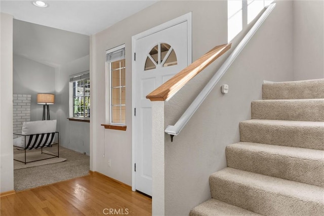 staircase with wood finished floors and recessed lighting