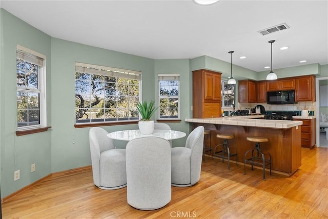 dining space featuring light wood-type flooring, visible vents, and recessed lighting