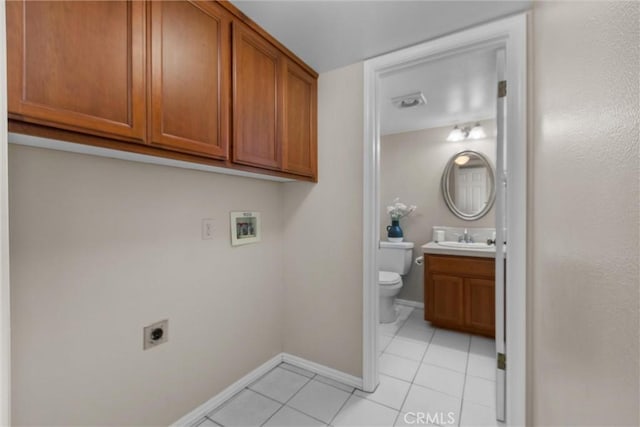 washroom with light tile patterned flooring, washer hookup, a sink, cabinet space, and electric dryer hookup