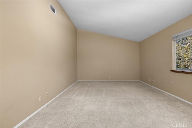 empty room featuring light colored carpet, visible vents, and baseboards