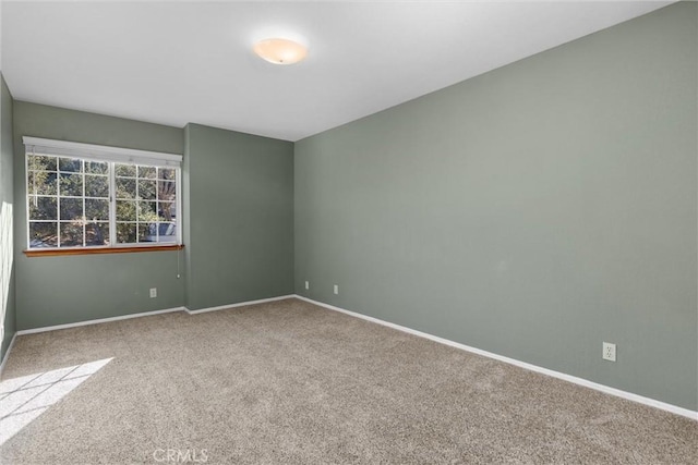 carpeted spare room with baseboards