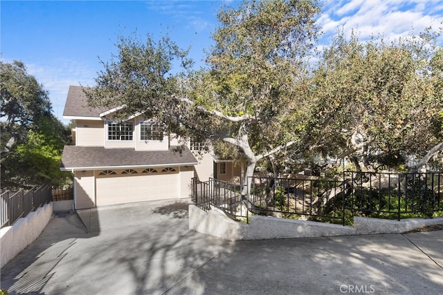 view of front of house featuring roof with shingles, fence, driveway, and an attached garage