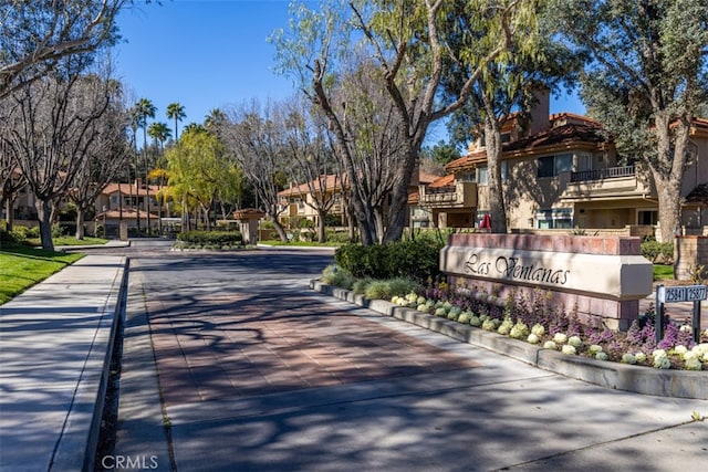 view of street featuring a residential view, a gated entry, and curbs