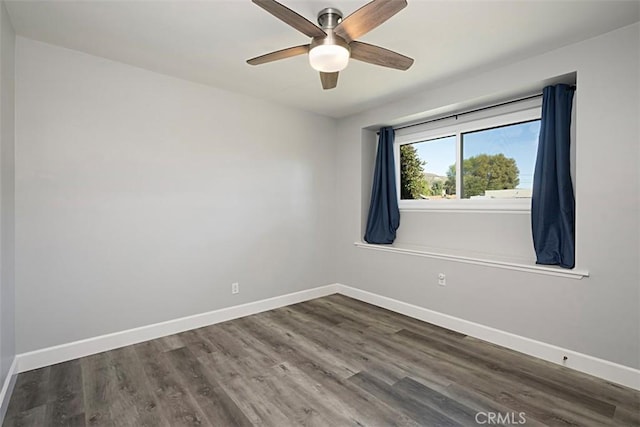 spare room with dark wood-style floors, baseboards, and a ceiling fan