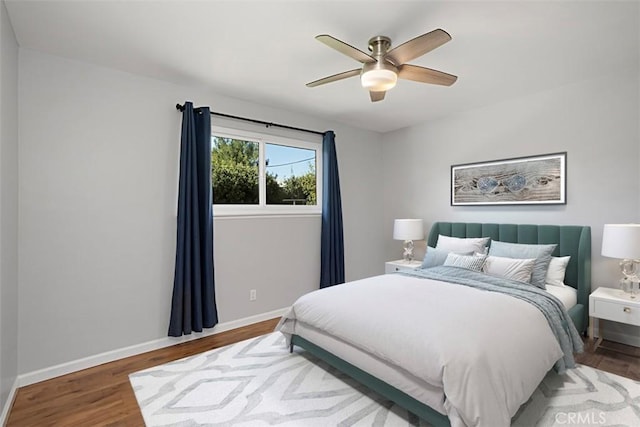 bedroom featuring a ceiling fan, baseboards, and wood finished floors