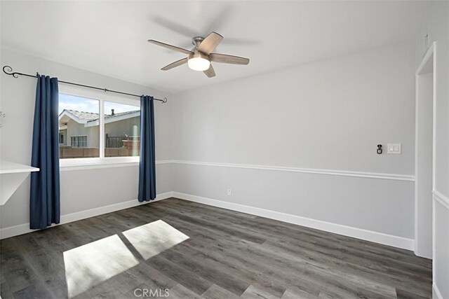 empty room with ceiling fan, baseboards, and wood finished floors