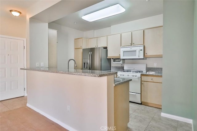 kitchen with white appliances, baseboards, a kitchen island, a sink, and light tile patterned flooring