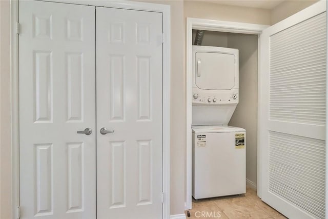 laundry room with laundry area, stacked washing maching and dryer, and light tile patterned floors