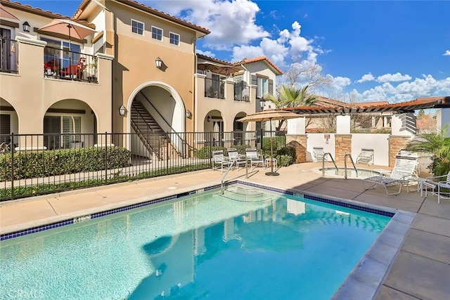 community pool featuring fence and a patio