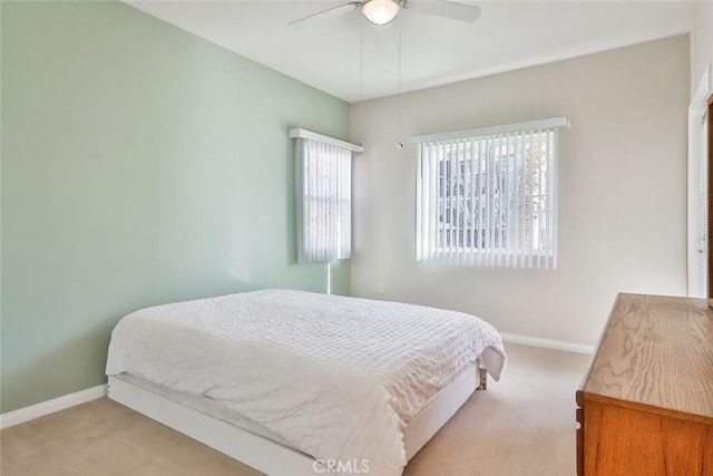 bedroom featuring light carpet, ceiling fan, and baseboards