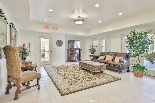 living room with recessed lighting, french doors, a glass covered fireplace, and light tile patterned floors