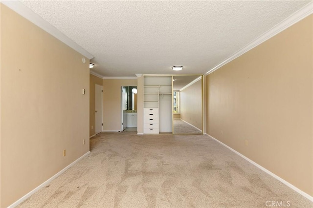 empty room with light carpet, crown molding, and baseboards