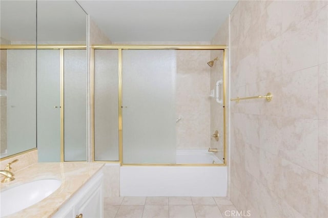 bathroom with combined bath / shower with glass door, tile walls, vanity, and tile patterned floors