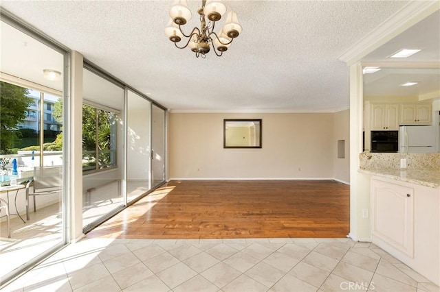 32709 Seagate Dr Unit 108, Rancho Palos Verdes, CA 90275 - unfurnished living room featuring light tile patterned floors, crown molding, a textured ceiling, baseboards, and a chandelier