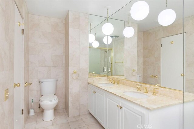 bathroom featuring a sink, tile patterned flooring, and tile walls