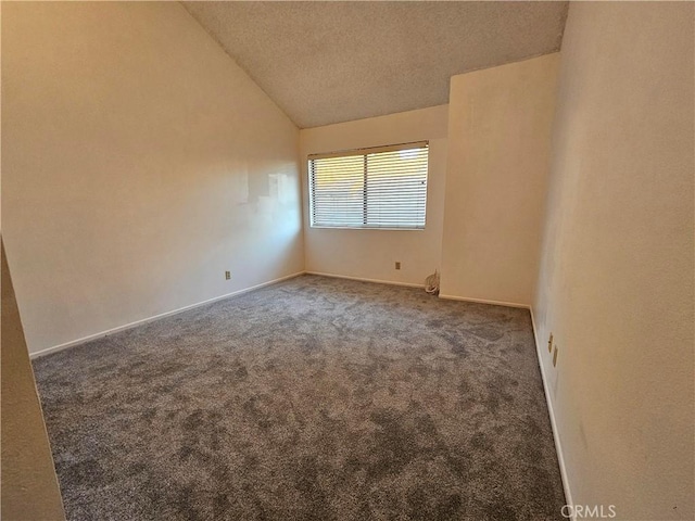 spare room with lofted ceiling, a textured ceiling, carpet, and baseboards