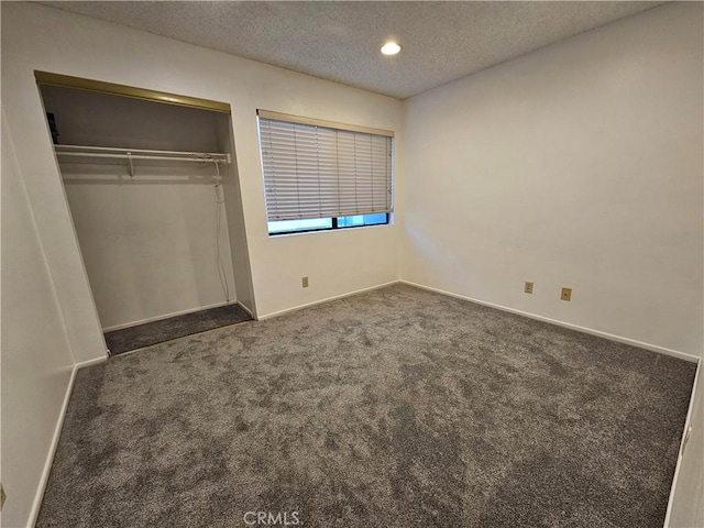 unfurnished bedroom with a textured ceiling, recessed lighting, baseboards, a closet, and dark colored carpet