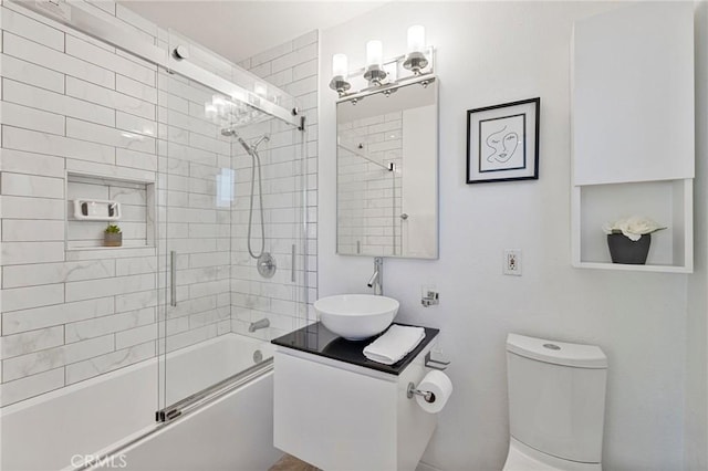 full bath featuring enclosed tub / shower combo, vanity, and toilet