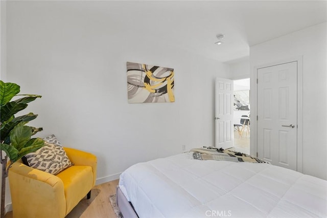 bedroom with baseboards and wood finished floors