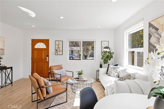 living area featuring recessed lighting, baseboards, and light wood finished floors