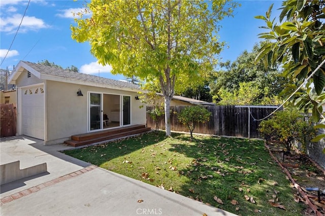 view of yard with fence and an attached garage