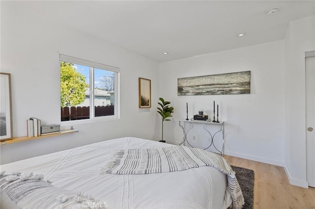 bedroom with baseboards and wood finished floors