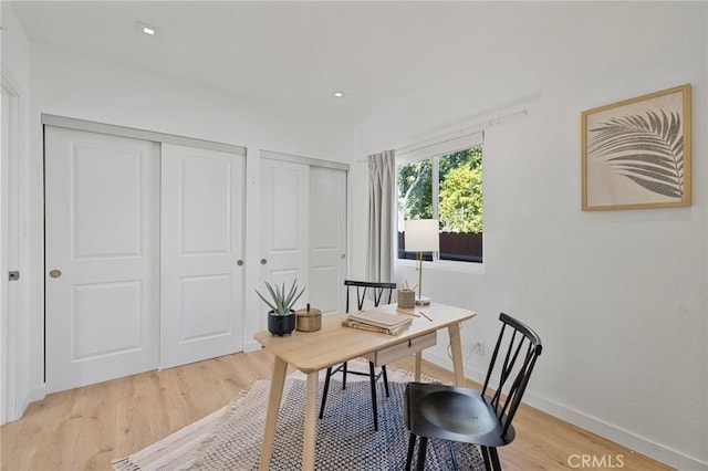 home office with baseboards and light wood finished floors