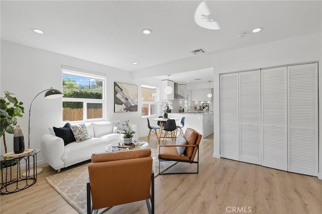 living area featuring light wood-style flooring, visible vents, and recessed lighting