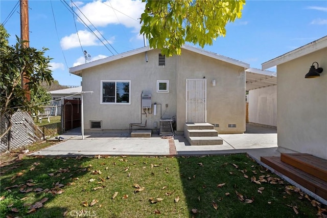 back of property with a patio area, fence, a lawn, and stucco siding