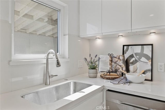 details with light countertops, white cabinetry, a sink, and modern cabinets