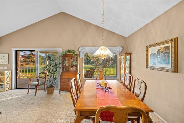 carpeted dining room with high vaulted ceiling