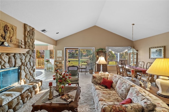 living room featuring carpet, a fireplace, vaulted ceiling, and visible vents