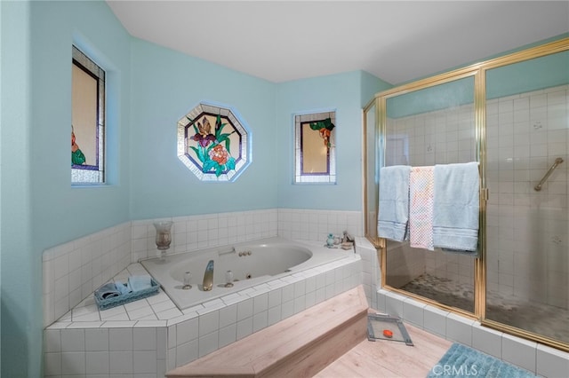 bathroom featuring a jetted tub and a shower stall