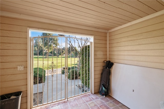 entryway featuring wood ceiling, wooden walls, and tile patterned flooring