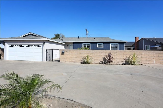 ranch-style house with a garage, a fenced front yard, and concrete driveway