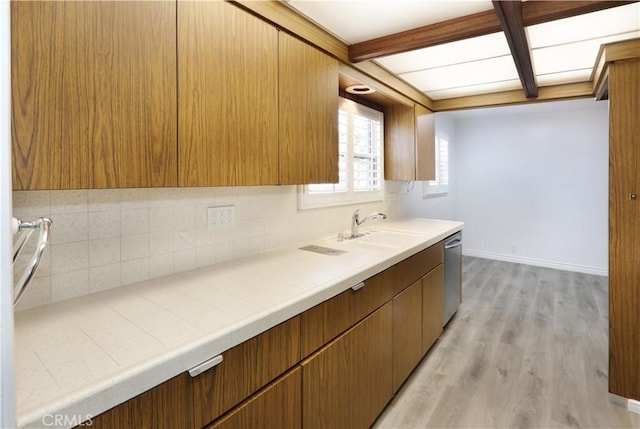 kitchen featuring brown cabinets, light countertops, and dishwasher